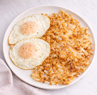 Eggs and hash browns on a white plate.